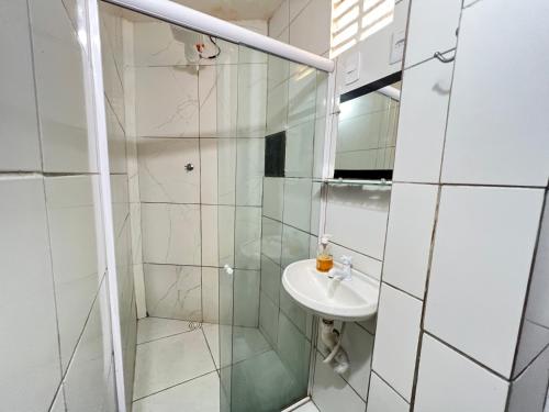 a bathroom with a glass shower and a sink at Suítes Verano in Baía Formosa