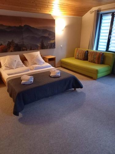 a large bedroom with a bed and a couch at Villa Falsztyn Holiday Home in Falsztyn
