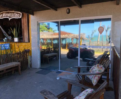 een toegang tot een restaurant met een reflectie van een auto in het raam bij Suítes Verano in Baía Formosa
