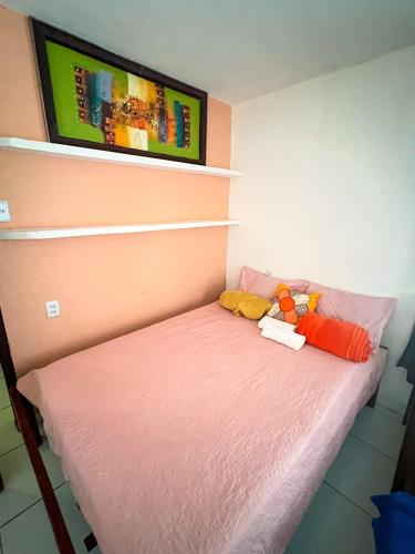 uma pequena cama com dois bichos de peluche sentados nela em Suítes Verano em Baía Formosa