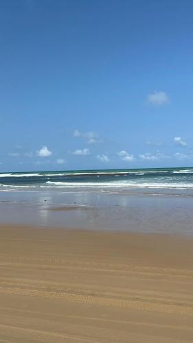 einen Sandstrand mit dem Ozean im Hintergrund in der Unterkunft Suítes Verano in Baía Formosa