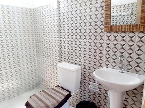 a bathroom with a white toilet and a sink at Natal Chalés Nova Caraiva in Caraíva