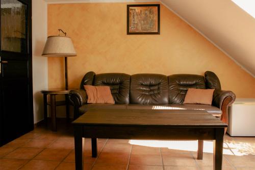 a living room with a leather couch and a table at Črni Baron Pension Black Baron in Maribor