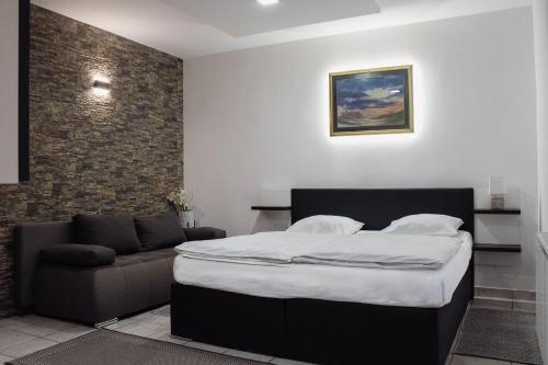 a bedroom with a bed and a couch at Črni Baron Pension Black Baron in Maribor