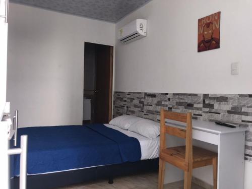 a small bedroom with a bed and a desk at The Mendoza Grand Hotel in Barranquilla