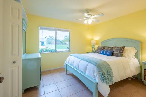 um quarto com uma cama, uma ventoinha de tecto e uma janela em Avonsdale Cir Pool and Tiki Hut Home in Port Charlotte 33948 em Port Charlotte