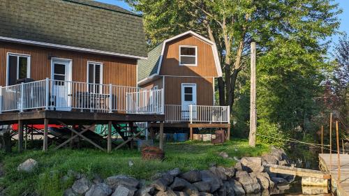 a house with a deck next to a body of water at Pourvoirie Stéphane Marin in Maskinongé