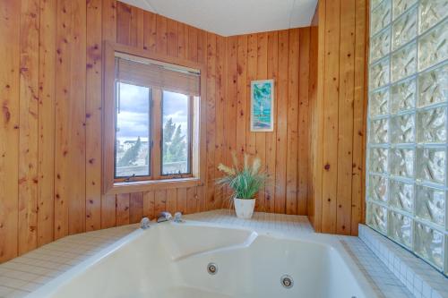 a bath tub in a room with wooden walls and a window at 5737 - Diamond by the Sea by Resort Realty in Nags Head