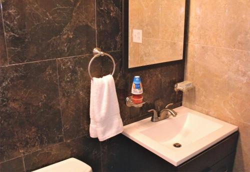a bathroom with a sink and a white towel at Luxury Villa Bonita Sleep 50 + in Isabela