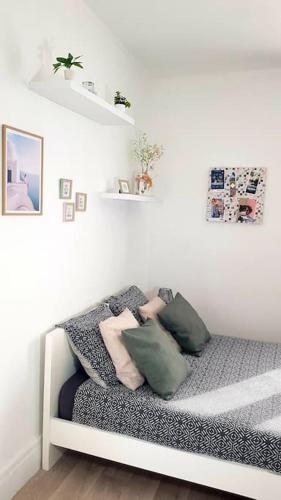 Cette chambre dispose d'un canapé et d'oreillers. dans l'établissement Le Chat Bleu - 26m2- Terrasse sur les toits - Wi-fi, à Amiens