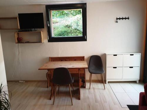 une chambre avec une table, des chaises et une fenêtre dans l'établissement Studio agréable avec accès indépendant., à Yverdon-les-Bains