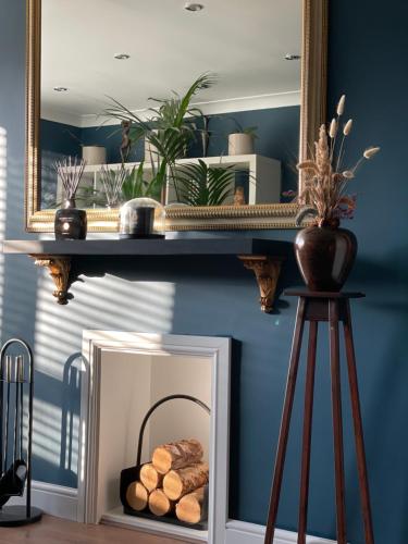 un espejo en una pared con una cesta de troncos en Luxury mid century Apartment en Londres