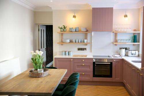 uma cozinha com uma mesa de madeira e uma sala de jantar em No 1 St George’s Terrace. em Carrick on Shannon