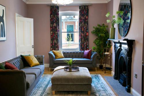 een woonkamer met 2 banken en een open haard bij No 1 St George’s Terrace. in Carrick on Shannon