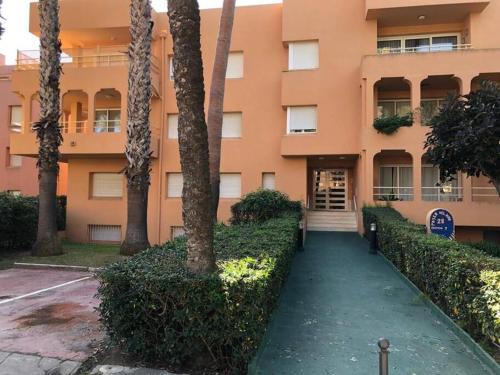un edificio con una pasarela delante de un edificio en Charming 3 Bedroom apartment with sea view in the heart of Sotogrande, en Sotogrande
