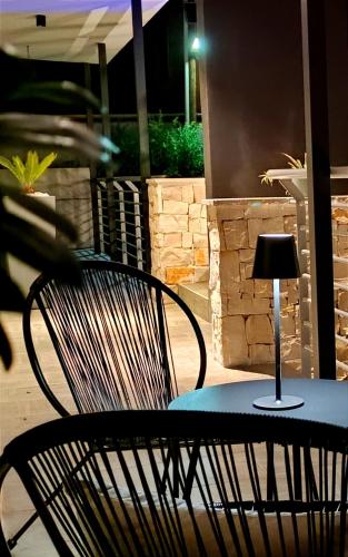a table with a chair and a lamp on it at Kemilia Matera in Matera