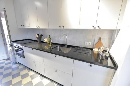 a kitchen with white cabinets and a sink at Casa de Piedras by SIERRA VIVA desing in Cortelazor