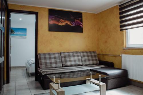 a living room with a couch and a glass table at Črni Baron Pension Black Baron in Maribor