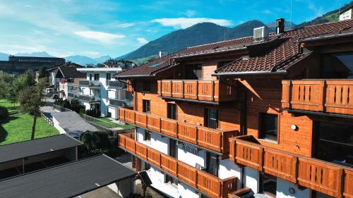a group of buildings with wooden balconies on them at OLDWOOD CHALET - Cozy Alpine Apartment with Balcony in Zillertal, presented by AlpenLuxus in Fügen