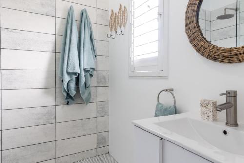 a bathroom with a sink and a mirror at Atlantic Beach Cottage in Langebaan