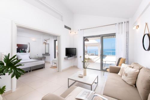 a living room with a couch and a bed at Mare Dei Suites Hotel Ionian Resort in Skafidia