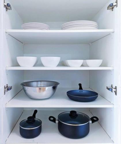 a shelf with pots and pans and plates in a kitchen at The Lilac Bungalow in Kingston