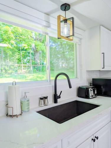 a kitchen with a black sink and a window at The Lilac Bungalow in Kingston