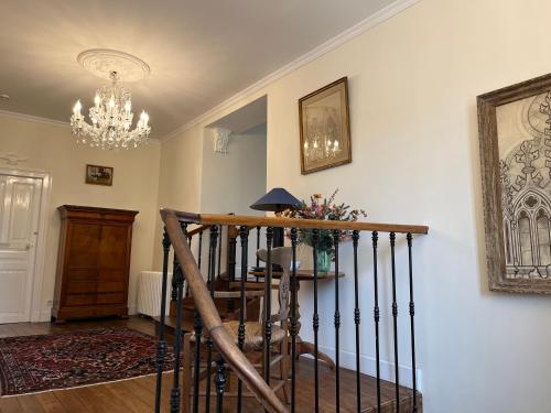 a living room with a staircase and a chandelier at Manoir du Val Fouzon - Beauval in La Vernelle
