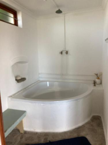 a white bath tub in a white room at Rondawel with sea view in Kleinmond