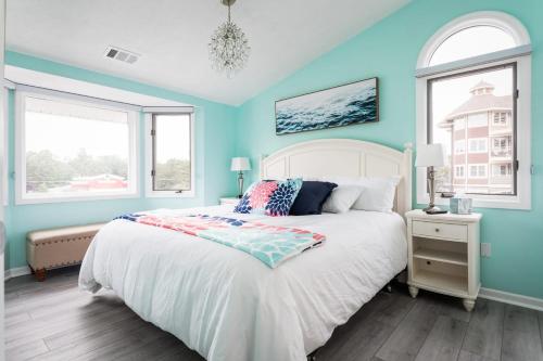 a bedroom with a bed with blue walls and windows at Beach 321 with Vaulted Ceilings Pool Hot Tub and Stunning Views from Private Deck in Traverse City