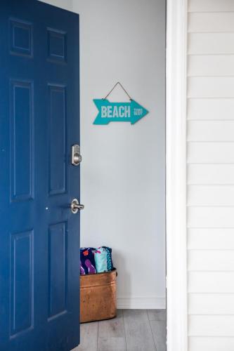 a blue door with a beach sign on it at Beach 321 with Vaulted Ceilings Pool Hot Tub and Stunning Views from Private Deck in Traverse City