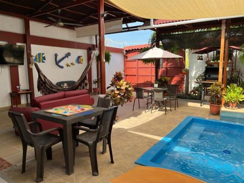 Un patio con mesa y sillas y una piscina. en Rancho Ayala, en Santa Marta