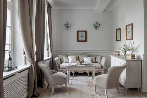 a living room with a couch and a table and chairs at Pałac Kamieniec in Polanica-Zdrój