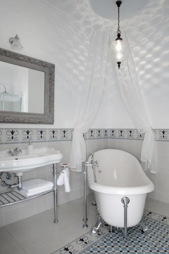 a white bathroom with a tub and a sink at Pałac Kamieniec in Polanica-Zdrój