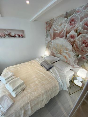 - une chambre avec un lit orné de roses sur le mur dans l'établissement Esprit Romantique, à Mulhouse
