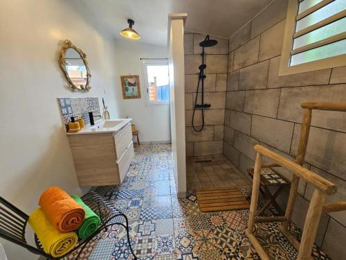 La salle de bains est pourvue d'une douche et d'un lavabo. dans l'établissement Canne Mapou, l'Escale Nature, à Trois Bassins