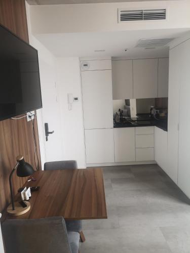 a living room with a wooden table and a kitchen at Magnolia Loft Apartments in Wrocław