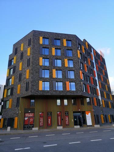 a tall building with colorful windows on a street at Magnolia Loft Apartments in Wrocław