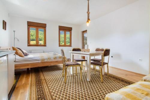 a living room with a table and chairs and a bed at Apartmani Jelenača prizemlje in Trnovo