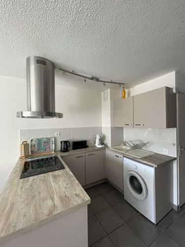 une cuisine avec un lave-linge et un lave-linge dans l'établissement Bel appartement au pied du marché noel, au Barcarès