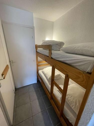 - 2 lits superposés dans une petite chambre avec une porte dans l'établissement Bel appartement au pied du marché noel, au Barcarès