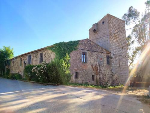 an old brick building with ivy growing on it at Mas Fina in Palafrugell
