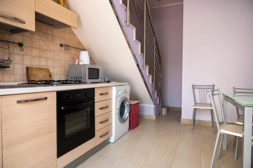 a kitchen with a washer and dryer and a staircase at Villa Calliope Pool sea View in Fontane Bianche