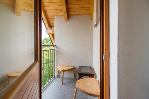 a room with a balcony with a table and a chair at Apartmani Jelenača in Sinanovići