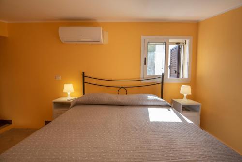 a bedroom with a large bed with two night stands at Villa Calliope Pool sea View in Fontane Bianche