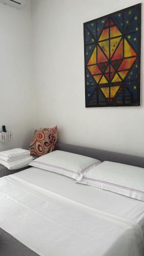 a bed in a room with a painting on the wall at Bilocale Carrara Centro con giardino e parcheggio moto in Carrara