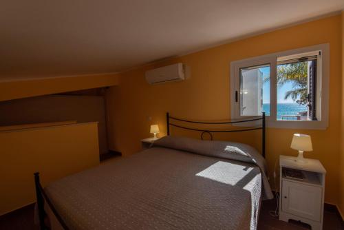 1 dormitorio con cama y ventana en Villa Calliope Sea Beach, en Fontane Bianche