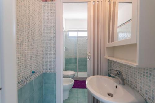 a bathroom with a sink and a toilet at Villa Calliope Pool sea View in Fontane Bianche