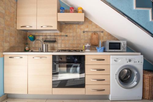 a kitchen with a washer and a washing machine at Villa Calliope Pool sea View in Fontane Bianche