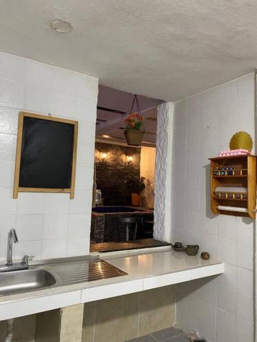 a kitchen with a sink and a tv on the wall at Casatoca House Zapatoca Lengerke in Zapatoca